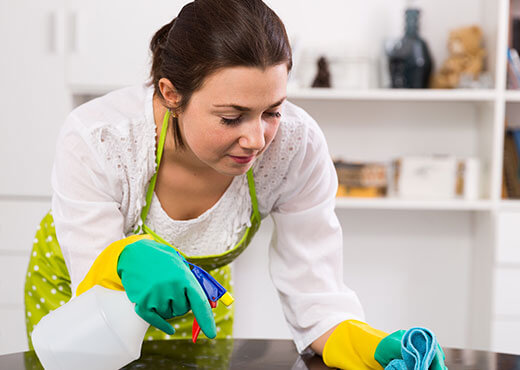 Professional home cleaning service in Dubai with expert maid cleaning a table.