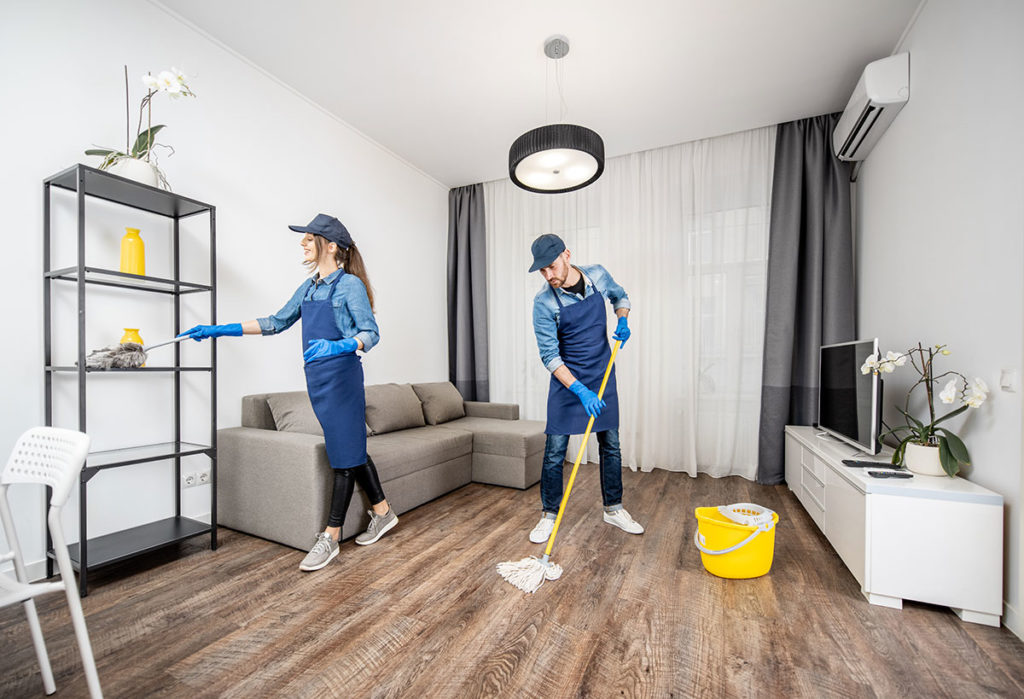 Professionally cleaned luxury apartment in Palm Jumeirah with plush sofa, polished surfaces, and breathtaking Arabian Gulf view, exemplifying CleanMyHouseService's meticulous attention to detail and cleanliness. The spacious living room showcases pristine hardwood floors and a gleaming kitchen.